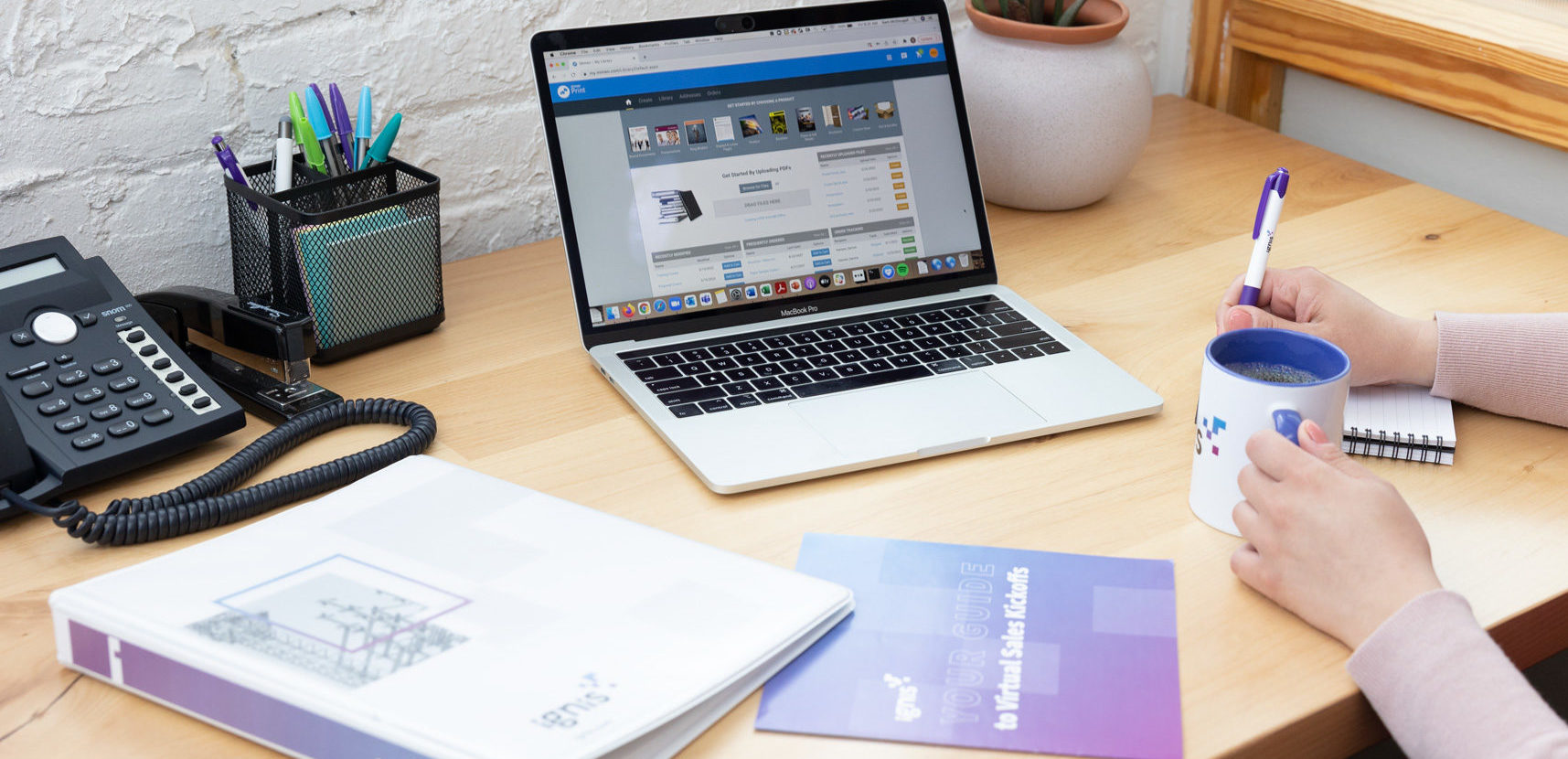 Person using printed sales products and taking notes while viewing Mimeo Print Platform