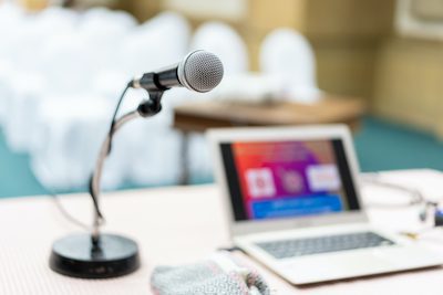 d microphone set up on the front of conference room close up with blurred background.  Wired microphone close up with copy space background.