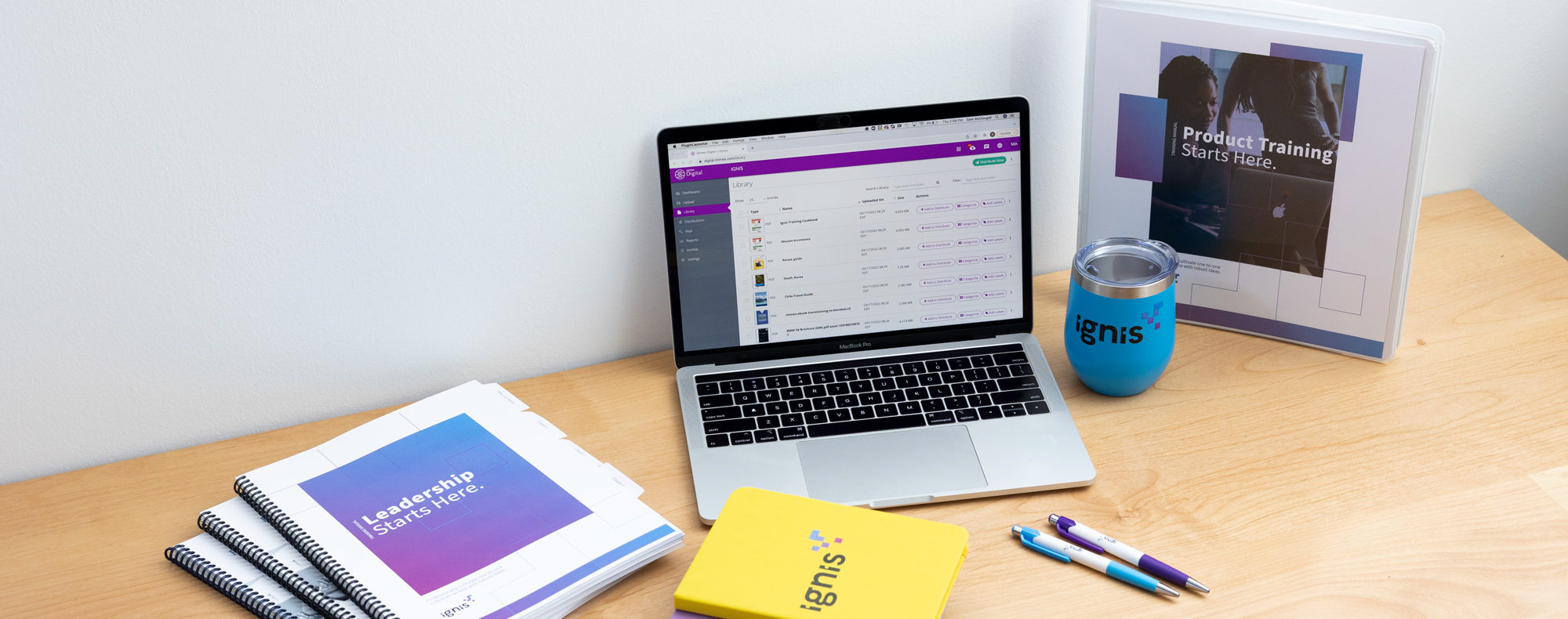 Mimeo Digital Platform on laptop alongside branded merchandise and printed manuals
