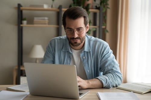 man watching virtual training with printed materials