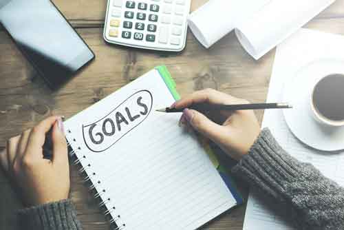 Woman Writing Goals in Notebook
