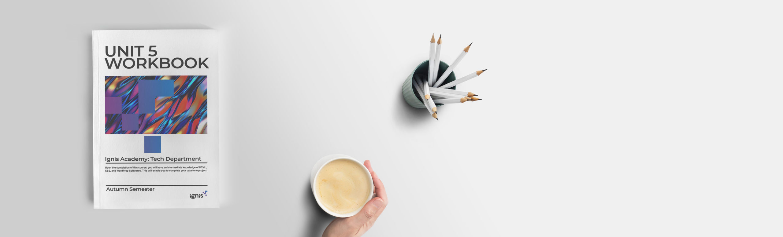 workbook on table next to person drinking coffee and cup of pencils