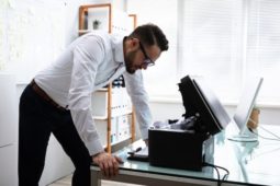 man wasting productivity time on printing