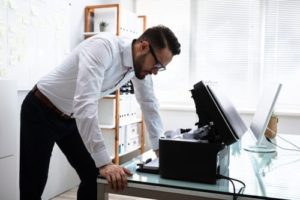 man wasting productivity time on printing