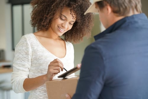 woman signing for overnight package delivery