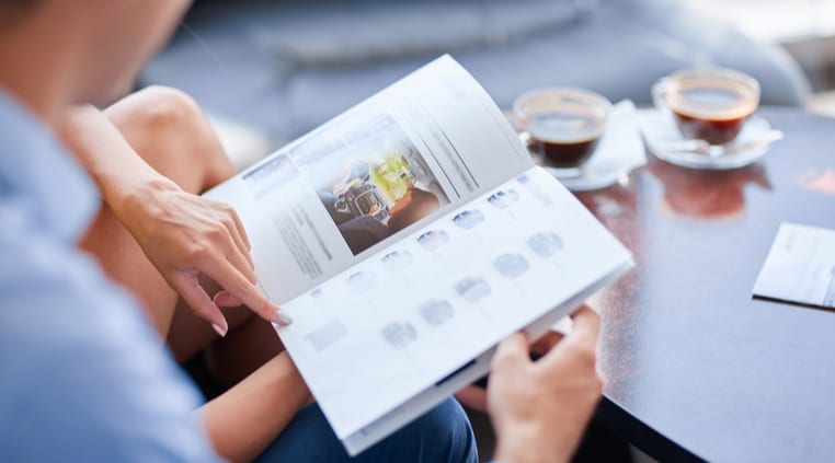 Two people reading printed booklets