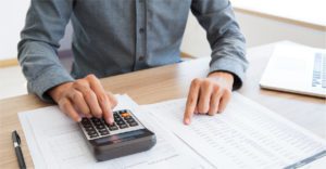 person working on print budget with calculator